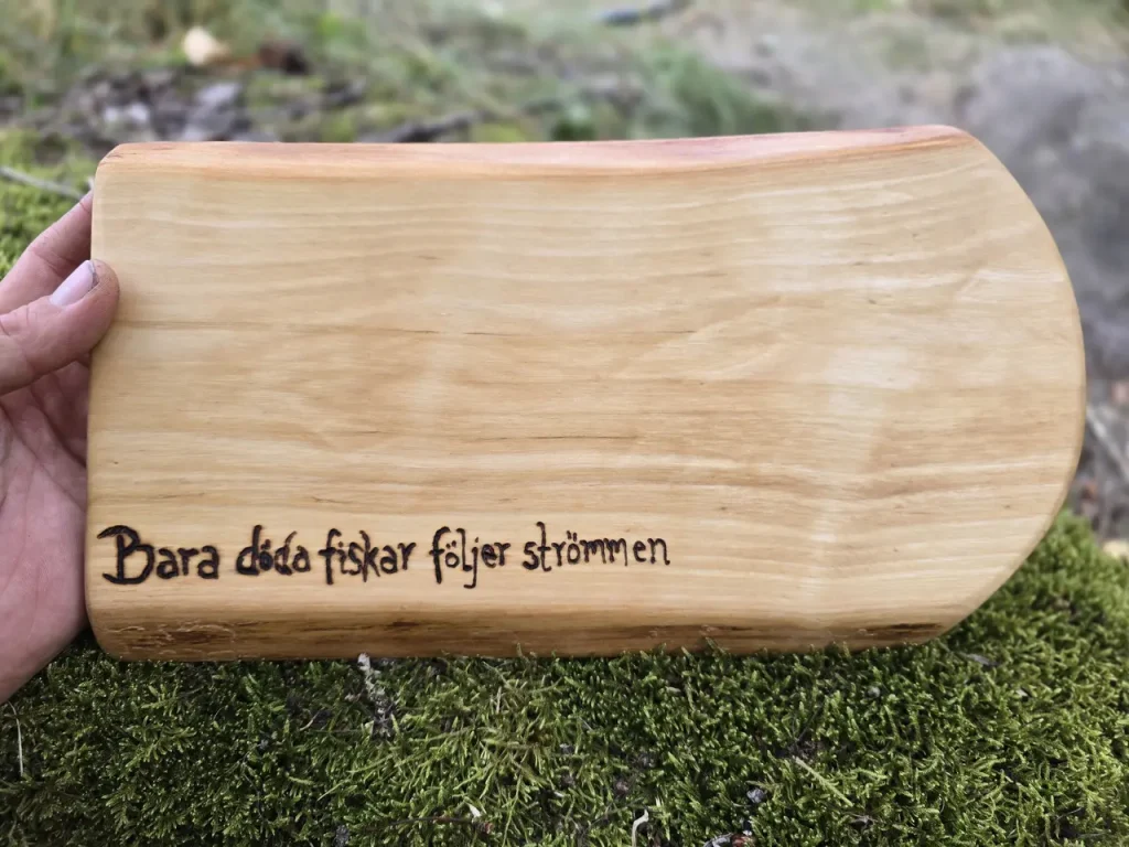 Skärbräda av okantad björk med visdomsord